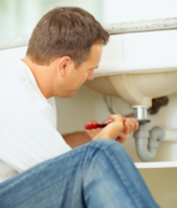 plumber in Tacoma washington repairs a bathroom sink drain